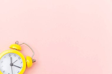 Pembe renkli renkli pastel arka planda izole edilmiş klasik alarmlı ikiz zil çalar saati. Hayatın dinlenme saatleri. İyi sabahlar. Uyanık kalma kavramı. Düz görünüm kopyalama alanı.