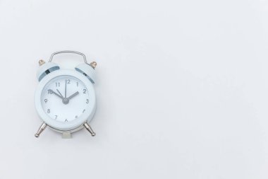 Basitçe düz dizayn edilmiş beyaz zemin üzerinde izole edilmiş klasik alarm saatini çalıyordu. Hayatın dinlenme saatleri. İyi sabahlar. Uyanık kalma kavramı. Düz görünüm kopyalama alanı.