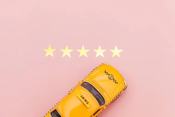 Yellow toy car Taxi Cab and 5 stars rating isolated on pink background. Smartphone application of taxi service for online searching calling and booking cab concept. Taxi symbol. Copy space. — Stock Photo, Image