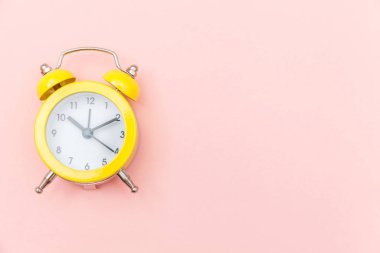 Pembe renkli renkli pastel arka planda izole edilmiş klasik alarmlı ikiz zil çalar saati. Hayatın dinlenme saatleri. İyi sabahlar. Uyanık kalma kavramı. Düz görünüm kopyalama alanı.