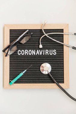 Text phrase Coronavirus syringe and stethoscope on black letter board background. Novel coronavirus 2019-nCoV, MERS-Cov middle East respiratory syndrome coronavirus originating in Wuhan China