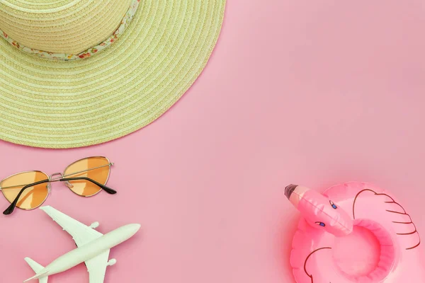 Summer beach composition. Minimal simple flat lay with plane sunglasses hat and Inflatable flamingo isolated on pastel pink background. Vacation travel adventure trip concept. Top view copy space. — Stock Photo, Image