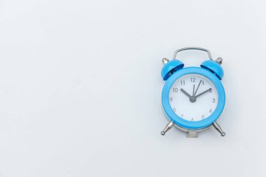 Basitçe düz dizayn edilmiş beyaz zemin üzerinde izole edilmiş klasik alarm saatini çalıyordu. Hayatın dinlenme saatleri. İyi sabahlar. Uyanık kalma kavramı. Düz görünüm kopyalama alanı.