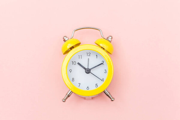 Ringing twin bell vintage classic alarm clock Isolated on pink colourful trendy pastel background. Rest hours time of life good morning night wake up awake concept. Flat lay top view copy space.