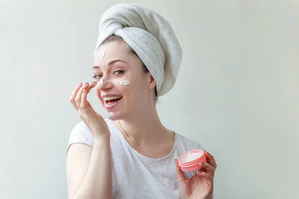 Ομορφιά πορτρέτο της γυναίκας με πετσέτα στο κεφάλι με λευκή θρεπτική μάσκα ή κρέμα στο πρόσωπο, λευκό φόντο απομονωμένο. Καθαρισμός δέρματος eco οργανικό καλλυντικό spa χαλαρώστε έννοια. — Φωτογραφία Αρχείου