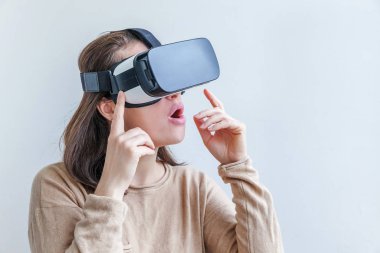 Beyaz arka planda sanal gerçeklik gözlüğü başlığı takan genç kadın gülümse. Sanal gerçeklik gözlüğü takan akıllı telefon. Teknoloji, simülasyon, yüksek teknoloji, video oyunu konsepti.