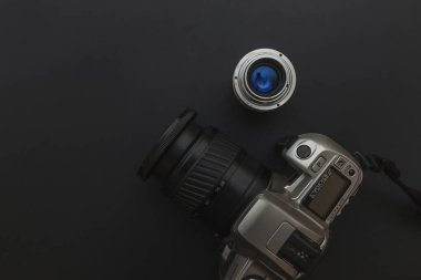 Karanlık masa arka planında DSR kamera sistemi ve lensleri olan fotoğrafçı işyeri. Hobi seyahat fotoğrafçılık konsepti. Düz görünüm kopyalama alanı.