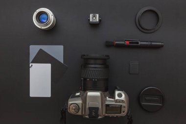 DSR kamera sistemi olan fotoğrafçı işyeri, kamera temizleme seti, siyah masa arka planında lens ve kamera aksesuarı. Hobi seyahat fotoğraf konsepti Düz görünüm kopya alanı yatıyordu