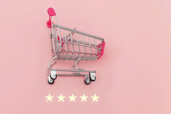 Malý supermarket nákupní vozík pro nákupy hraček s kolečky a 5 hvězdiček hodnocení izolované na pastelově růžovém pozadí. Maloobchodní spotřebitel nákup on-line posouzení a přezkoumání koncepce. — Stock fotografie