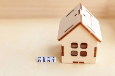 Minyatür oyuncak model ev kira harf kelime ahşap zemin üzerinde yazıt ile. Eko Köyü, çevre arka plan. Emlak mortgage Emlak sigorta tatlı ev ekoloji kira kavramı