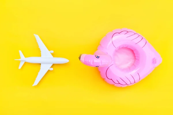 Composição de praia de verão. Deitado plano simples mínimo com plano e flamingo inflável isolado no fundo amarelo. Viagem de férias conceito de viagem de aventura. Espaço de cópia da vista superior. — Fotografia de Stock