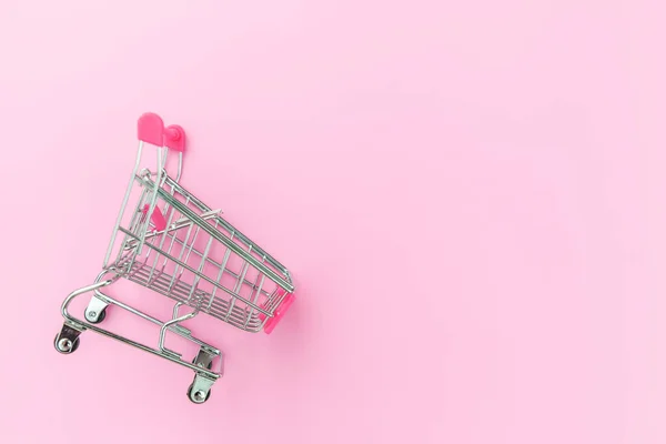 ピンクのパステルカラフルなトレンディな背景に隔離されたホイールを持つショッピングおもちゃのための小さなスーパーマーケットの食料品プッシュカート。販売は、モール市場ショップ消費者の概念を購入します。スペースのコピー. — ストック写真