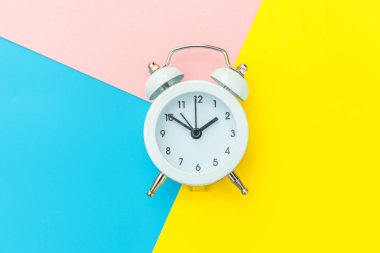 Çalan ikiz çan klasik alarm saati mavi pembe renkli renkli geometrik arkaplanda izole edilmiş. Hayatın dinlenme saatleri. İyi sabahlar. Uyanık kalma kavramı. Düz görünüm kopyalama alanı.
