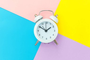 Çalan ikiz çan klasik alarm saati mavi pembe renkli renkli geometrik arkaplanda izole edilmiş. Hayatın dinlenme saatleri. İyi sabahlar. Uyanık kalma kavramı. Düz görünüm kopyalama alanı.