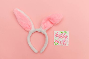 Mutlu Paskalya kavramı. Tatil için hazırlık. Yazıt Happy Easter izole trendy pastel pembe arka plan üzerinde dekoratif tavşan kulakları mektuplar. Üstten görünüm kopya alanı basit minimalizm düz yatıyordu.
