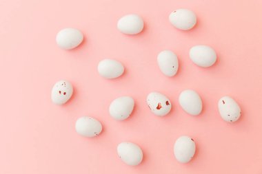 Mutlu Paskalya konsepti. Paskalya şekeri çikolata yumurta ve Jellybean tatlılar trendy pastel pembe arka planda izole. Basit minimalizm düz üst görünüm kopya alanı yatıyordu