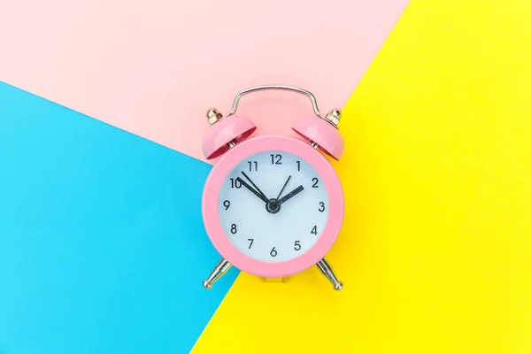 Dering twin bell jam alarm klasik Terisolasi pada biru kuning pastel merah muda Berwarna latar belakang geometris. Istirahat jam waktu kehidupan baik pagi bangun bangun konsep terjaga. Ruang salinan tilikan atas rata. — Stok Foto