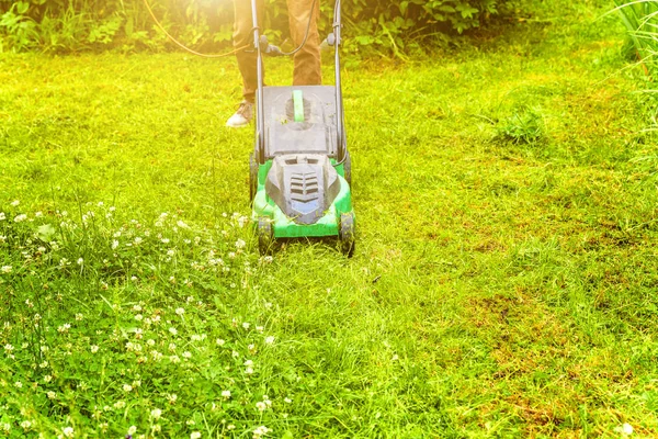 Homem cortando grama verde com cortador de grama no quintal. Jardinagem país estilo de vida fundo. Bela vista no gramado de grama verde fresco na luz solar, paisagem do jardim na primavera ou temporada de verão. — Fotografia de Stock