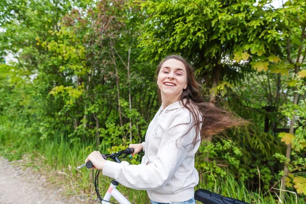 Jeune femme à vélo dans le parc de la ville d'été en plein air. Des gens actifs. Hipster fille se détendre et cycliste — Photo