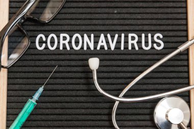 Text phrase Coronavirus syringe and stethoscope on black letter board background. Novel coronavirus 2019-nCoV, MERS-Cov middle East respiratory syndrome coronavirus originating in Wuhan China