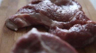 Şef profesyonel mutfakta ahşap kesme tahtasına et koyuyor. Pişmemiş çiğ bifteğe biberle eşlik etmenin en güzel manzarası. Enfes, modern mutfağı kapatın.