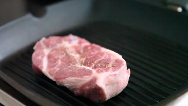 전문적 주방에서 위에서 고기를 튀기는 요리를 손으로 스테이크를 보이는 있습니다 — 비디오