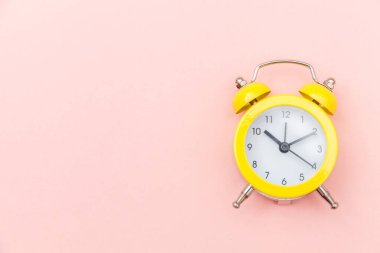 Pembe renkli renkli pastel arka planda izole edilmiş klasik alarmlı ikiz zil çalar saati. Hayatın dinlenme saatleri. İyi sabahlar. Uyanık kalma kavramı. Düz görünüm kopyalama alanı.