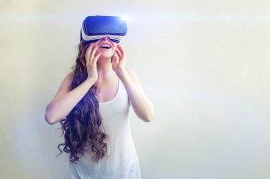 Beyaz arka planda sanal gerçeklik gözlüğü başlığı takan genç kadın gülümse. Sanal gerçeklik gözlüğü takan akıllı telefon. Teknoloji, simülasyon, yüksek teknoloji, video oyunu konsepti.