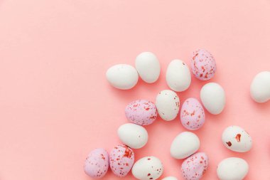 Mutlu Paskalyalar. Tatil için hazırlık. Paskalya şekerli çikolatalı yumurtalar ve jöleli şekerler modaya uygun pembe arka planda izole edilmiş. Basit minimalizm düz üst görünüm kopyalama alanı.