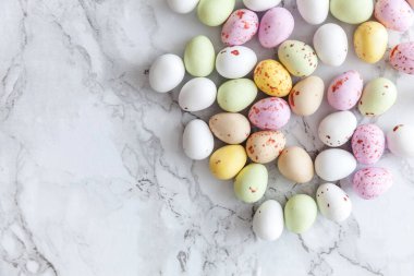 Mutlu Paskalyalar. Tatil için hazırlık. Paskalya pastel çikolatalı yumurtalar moda gri mermer arka planda. Basit minimalizm düz üst görünüm kopyalama alanı.