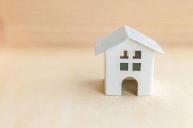 Ahşap zemin üzerinde minyatür oyuncak model ev. Eco Village soyut çevre geçmişi. Gayrimenkul ipoteği emlak sigortası tatlı ev ekolojisi kavramı
