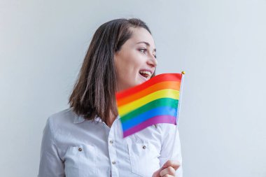 Beyaz arka planda izole edilmiş LGBT gökkuşağı bayraklı güzel beyaz lezbiyen kız mutlu ve heyecanlı görünüyor. Genç kadın Gay Gurur portresi. lgbtq topluluk kavramı için eşit haklar