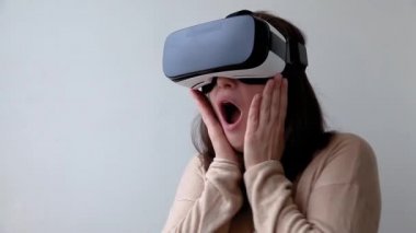 Beyaz arka planda sanal gerçeklik gözlüğü başlığı takan genç kadın gülümse. Sanal gerçeklik gözlüğü takan akıllı telefon. Teknoloji, simülasyon, yüksek teknoloji, video oyunu konsepti