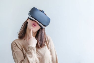 Beyaz arka planda sanal gerçeklik gözlüğü başlığı takan genç kadın gülümse. Sanal gerçeklik gözlüğü takan akıllı telefon. Teknoloji, simülasyon, yüksek teknoloji, video oyunu konsepti