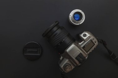 Karanlık masa arka planında DSR kamera sistemi ve lensleri olan fotoğrafçı işyeri. Hobi seyahat fotoğrafçılık konsepti. Düz görünüm kopyalama alanı
