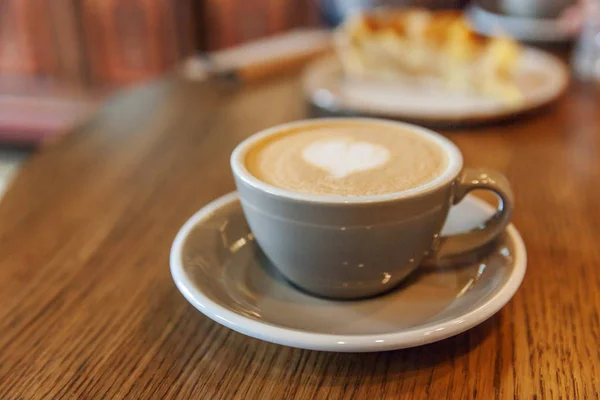 Coffee cup fresh cream organic cappuccino on table in cafe. Latte macchiato drink in glass close up. Wake up, morning addiction concept