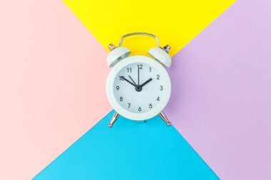 Çalan ikiz çan klasik alarm saati mavi pembe renkli renkli geometrik arkaplanda izole edilmiş. Hayatın dinlenme saatleri. İyi sabahlar. Uyanık kalma kavramı. Düz görünüm kopyalama alanı