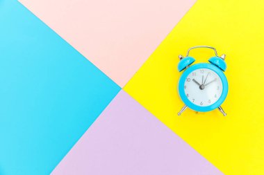 Çalan ikiz çan klasik alarm saati mavi pembe renkli renkli geometrik arkaplanda izole edilmiş. Hayatın dinlenme saatleri. İyi sabahlar. Uyanık kalma kavramı. Düz görünüm kopyalama alanı