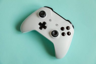 Siber uzay sembolü. Beyaz joystick oyun sahası, pastel mavi renkli arka planda izole edilmiş oyun konsolu. Bilgisayar oyunu yarışması video oyunu kontrol yüzleşme kavramı