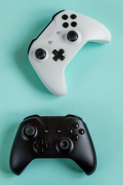 Beyaz ve siyah iki oyun alanı, oyun konsolu pastel mavi renkli arka planda izole edilmiş. Bilgisayar oyunu yarışması video oyunu kontrol yüzleşmesi konsepti. Siber uzay sembolü