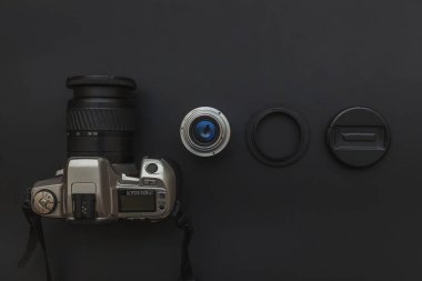 Karanlık masa arka planında DSR kamera sistemi ve lensleri olan fotoğrafçı işyeri. Hobi seyahat fotoğrafçılık konsepti. Düz görünüm kopyalama alanı
