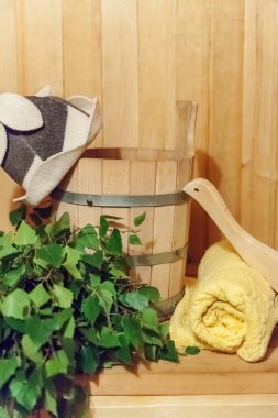 İçişleri, geleneksel sauna aksesuarları, süpürge kepçesi kepçeli şapka havlusuyla Finlandiya sauna sauna saunası detaylarını anlatıyor. Geleneksel eski Rus hamamı SPA konsepti. Rahatlayın köy banyosu konsepti