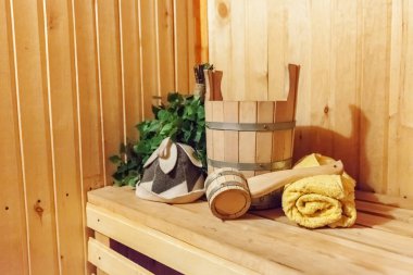 İçişleri, geleneksel sauna aksesuarları, süpürge kepçesi kepçeli şapka havlusuyla Finlandiya sauna sauna saunası detaylarını anlatıyor. Geleneksel eski Rus hamamı SPA konsepti. Rahatlayın köy banyosu konsepti