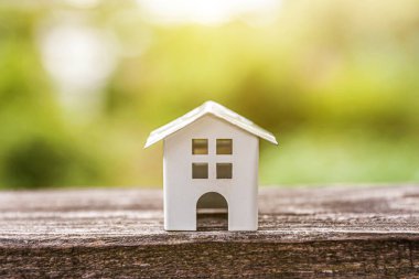 Yeşil zemin yakın ahşap arka planda minyatür beyaz oyuncak model ev