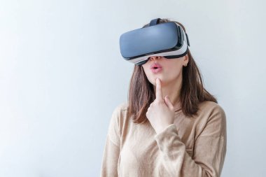 Beyaz arka planda sanal gerçeklik gözlüğü başlığı takan genç kadın gülümse. Sanal gerçeklik gözlüğü takan akıllı telefon. Teknoloji, simülasyon, yüksek teknoloji, video oyunu konsepti