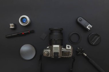 DSR kamera sistemi olan fotoğrafçı işyeri, kamera temizleme seti, siyah masa arka planında lens ve kamera aksesuarı. Hobi seyahat fotoğrafçılık konsepti. Düz görünüm kopyalama alanı