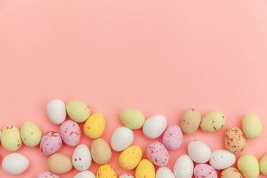 Mutlu Paskalyalar. Tatil için hazırlık. Paskalya şekerli çikolatalı yumurtalar ve jöleli şekerler modaya uygun pembe arka planda izole edilmiş. Basit minimalizm düz üst görünüm kopyalama alanı