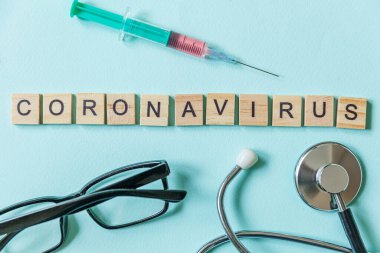 Mavi pastel arka planda Coronavirus şırınga gözlüğü ve steteskop ifadesi. Roman Coronavirus 2019-nCoV, MERS-Cov orta doğu solunum sendromu Coronavirüs kökenli Wuhan, Çin
