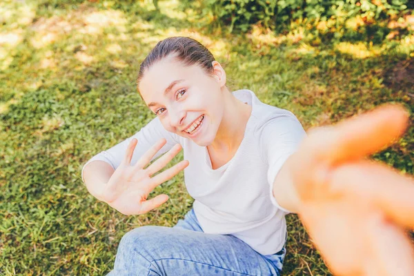 Mladá Legrační Dívka Vzít Selfie Rukou Telefonem Sedí Zeleném Trávníku — Stock fotografie