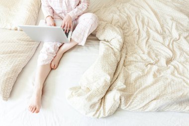 Mobil Ofis evde. Evde pijamalı genç bir kadın dizüstü bilgisayar kullanarak çalışıyor. Yaşam tarzı kızı içeride ders çalışıyor. Serbest ticaret karantina kavramı
